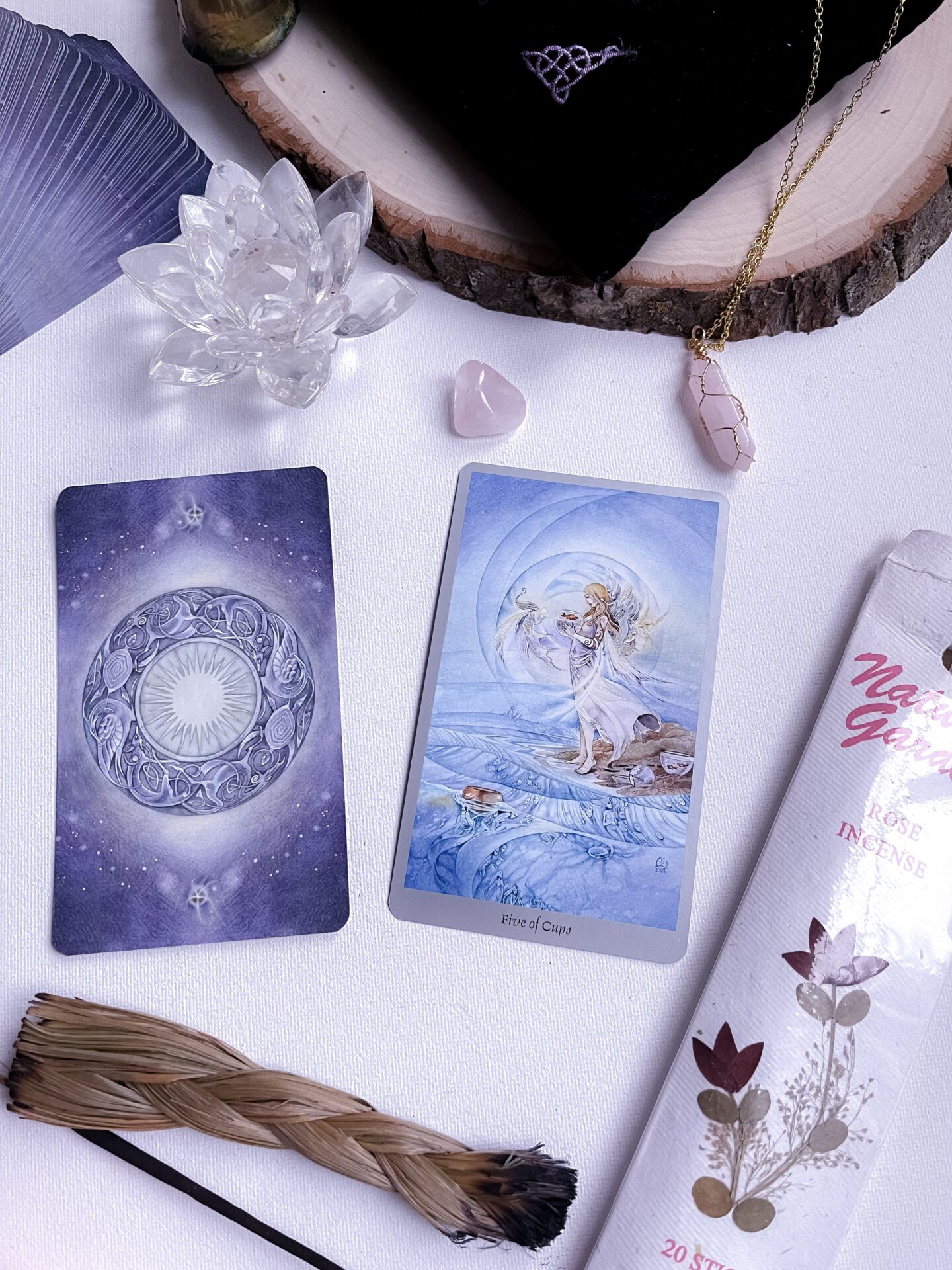 Intimate tarot card reading setup featuring crystals and incense for spiritual exploration.